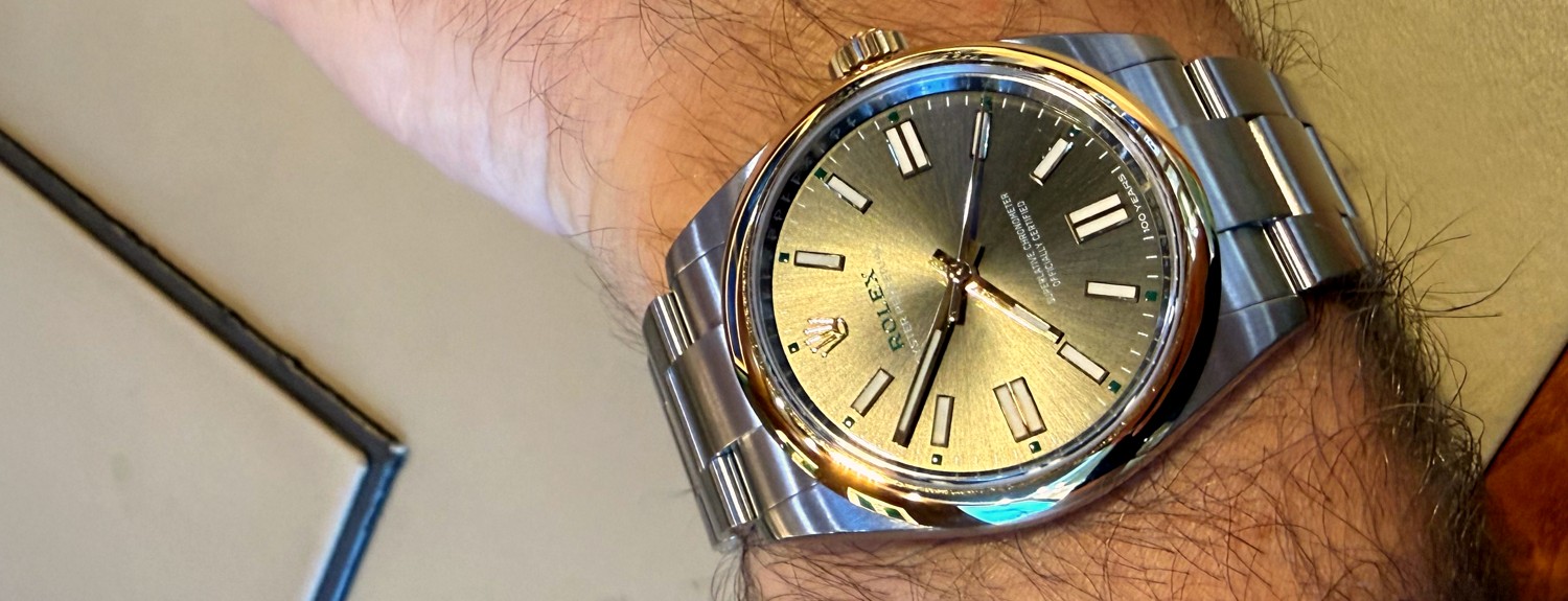 A Rolex Oyster Perpetual 41 Oyster 100 with gold bezel and slate sunburst dial